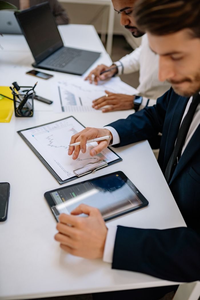 Business professionals working with tablet and documents in a modern office.