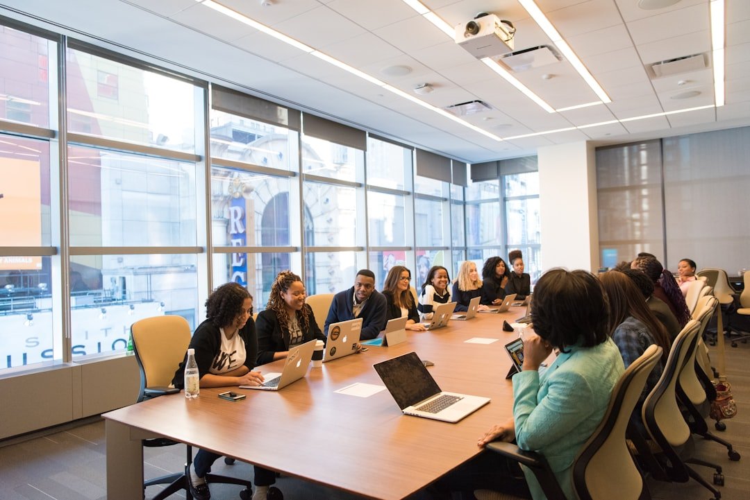 group-of-people-sitting-beside-rectangular-wooden-table-with-laptops-faefwcdokig
