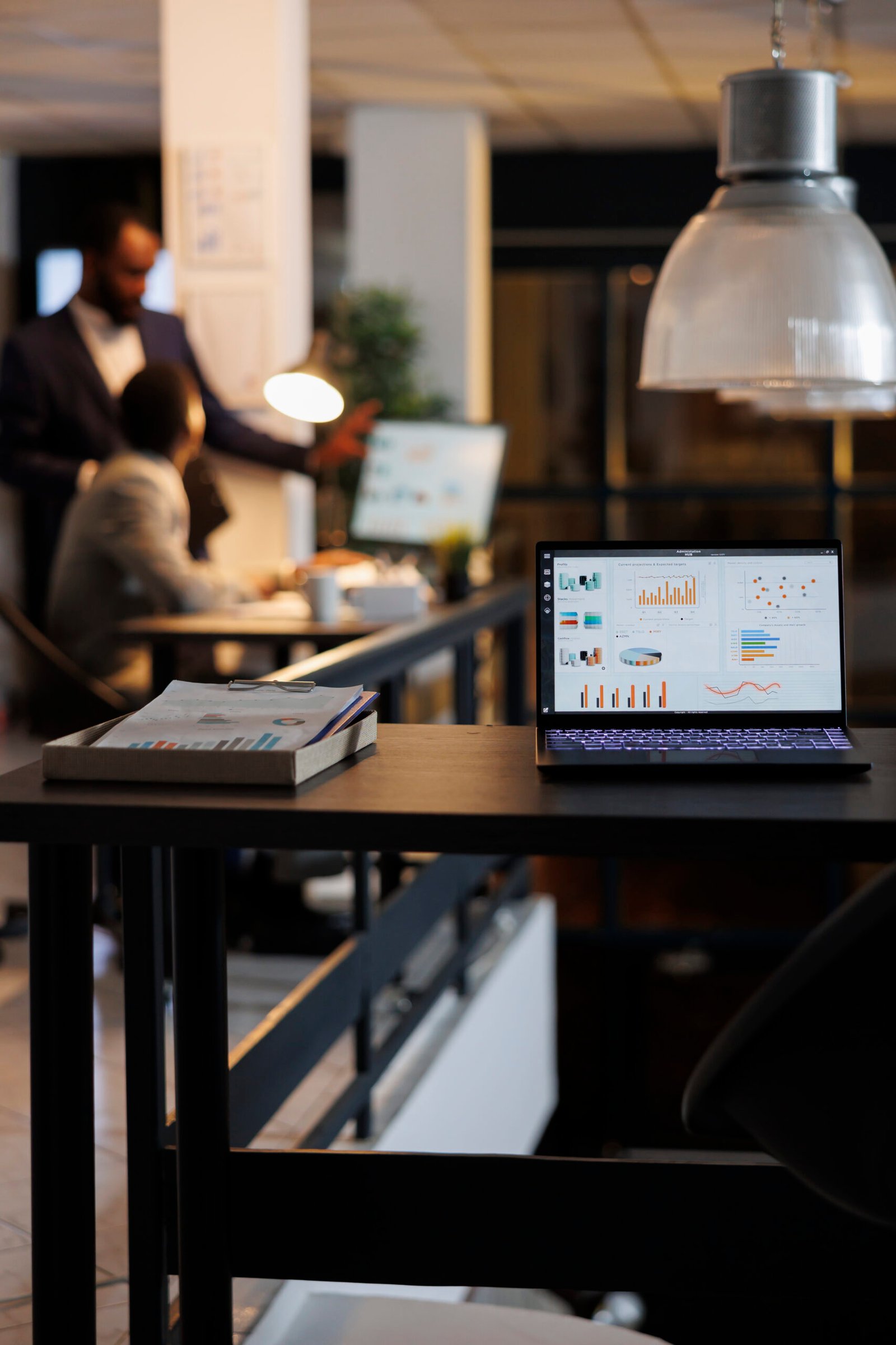laptop computer with financial graphs on screen
